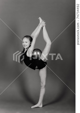 Young girl doing gymnastics over grey background Young girl doing gymnastics over grey background 74734492