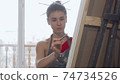 Elegant woman painting a picture at the workshop 74734526