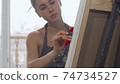 Sliding shot of a gorgeous young woman drawing a picture at art studio 74734527