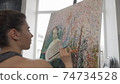 Cropped rear view shot of a woman painting at art studio 74734528