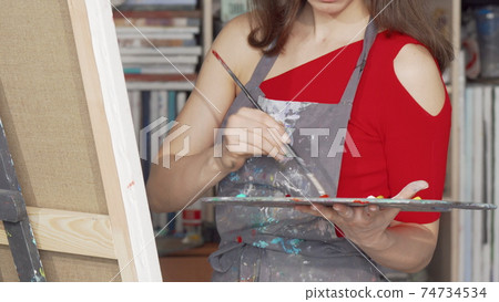 Sliding shot of a beautiful young woman drawing at the art studio Sliding shot of a beautiful young woman drawing at the art studio 74734534
