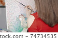 Cropped rear view shot of a female artist painting at art studio 74734535