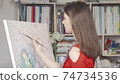 Beautiful young woman painting a picture at art workshop 74734536