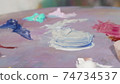 Unrecognizable female artist mixing paint on a palette 74734537