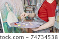 Cropped shot of a female artist mixing paint on her palette while drawing 74734538