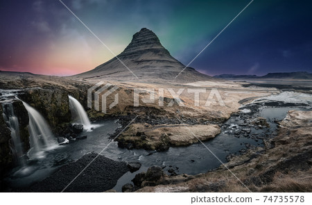 Northern lights aurora borealis over kirkjufell waterfall in Iceland 74735578