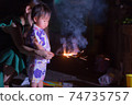 Parent and child holding handheld fireworks 74735757