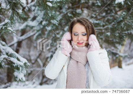 Woman look down and miles under the snow covered tree Woman look down and miles under the snow covered tree 74736087