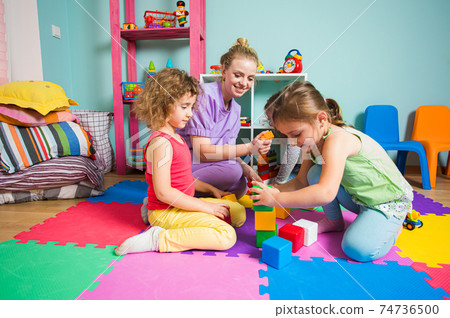 4-5 years girls make a tower from color cubes 74736500