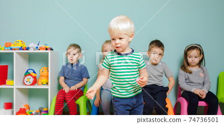 Children are sitting on the colorful chairs in the kindergarten Children are sitting on the colorful chairs in the kindergarten 74736501