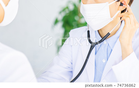 A doctor who applies a stethoscope to a male patient 74736862