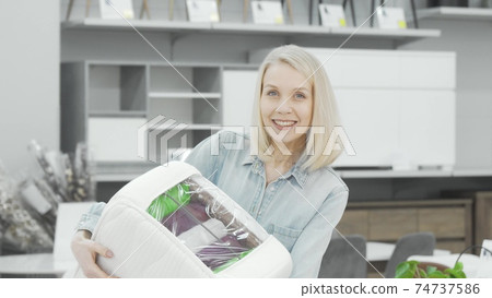 Beautiful young woman examining orthopedic mattress sample Beautiful young woman examining orthopedic mattress sample 74737586