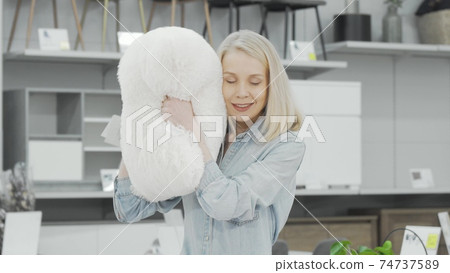 Happy beautiful young woman buying new pillow at home goods store Happy beautiful young woman buying new pillow at home goods store 74737589