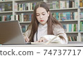 Teenage girl using computer at the library 74737717