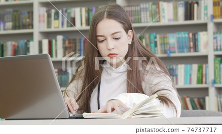 Teenage girl using computer at the library Teenage girl using computer at the library 74737717