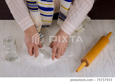 Orthodox Jewish man prepare hand made flat kosher matzah 74737933
