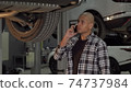 Young African man talking on the phone at car repair station 74737984
