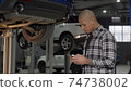 Handsome African man using smart phone at the garage 74738002