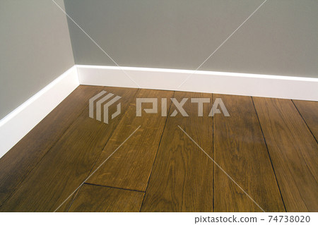 Close up of white plastic plinths on dark wooden oak floor parquet. 74738020