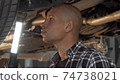 Cropped shot of a young male driver working at his garage 74738021