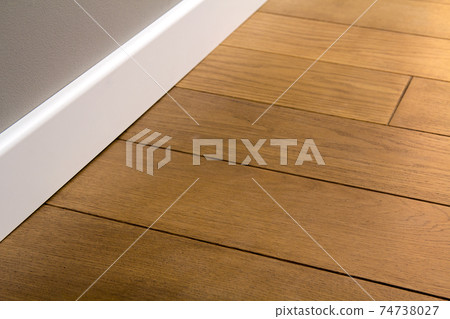 Close up of white plastic plinths on dark wooden oak floor parquet. 74738027