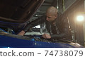 Young handsome man repairing his car at the garage 74738079