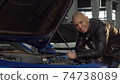 Cheerful handsome African man smiling to the camera while working at his garage 74738089