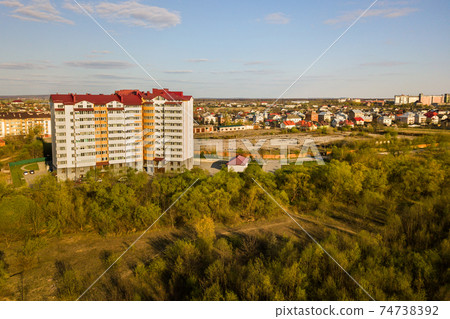 Aerial view of high residential apartment building in green rural area in Ivano-Frankivsk city, Ukraine Aerial view of high residential apartment building in green rural area in Ivano-Frankivsk city, Ukraine 74738392