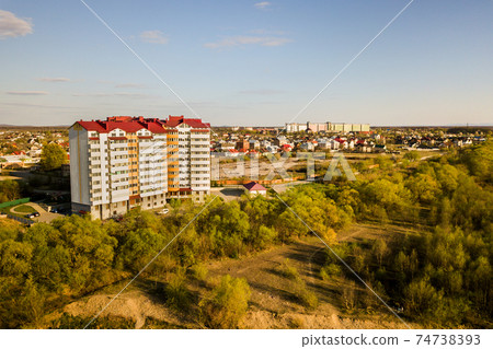 Aerial view of high residential apartment building in green rural area in Ivano-Frankivsk city, Ukraine Aerial view of high residential apartment building in green rural area in Ivano-Frankivsk city, Ukraine 74738393