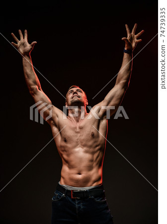 Handsome sexy man with muscular body pulls both 74739335