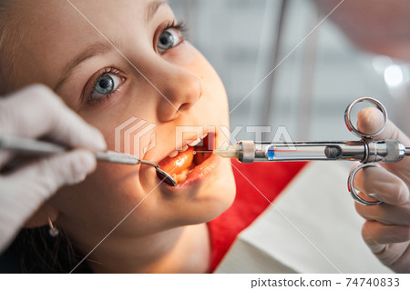 Girl getting local anesthesia injection into gums 74740833