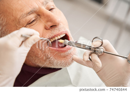 Patient getting an injection with anesthesia Patient getting an injection with anesthesia 74740844