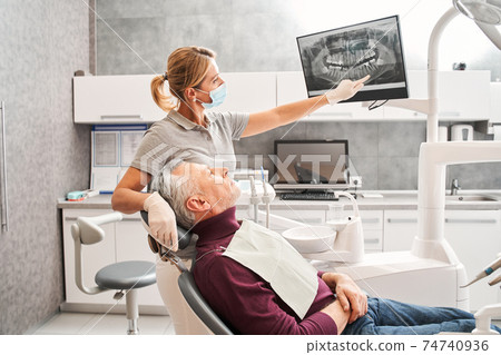Man looking at the x ray while listening doctor Man looking at the x ray while listening doctor 74740936