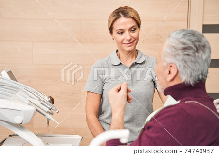 Dentist and patient discussing results of whitening 74740937