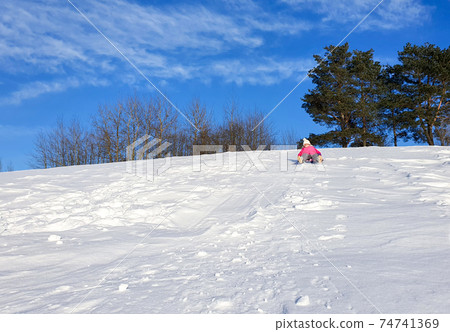 A child is tubing on a snow slide A child is tubing on a snow slide 74741369