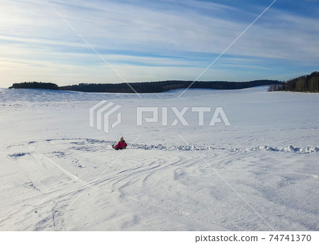A child is tubing on a snow slide 74741370