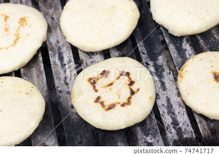 Toasted arepas cooking on the grill 74741717