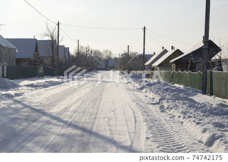 Winter rural road and trees in snow in Belarus 74742175
