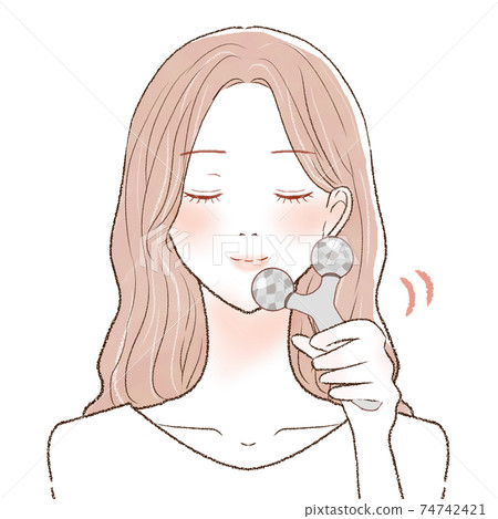 A woman who massages her face with a facial roller 74742421