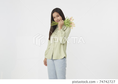 Spring Beautiful cheerful girl smiling and holding a bouquet of tulip flowers. Young happy woman. Surprise at the 8 March International Women's Day. Spring Beautiful cheerful girl smiling and holding a bouquet of tulip flowers. Young happy woman. Surprise at the 8 March International Women's Day. 74742727