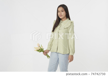 Spring Beautiful cheerful girl smiling and holding a bouquet of tulip flowers. Young happy woman. Surprise at the 8 March International Women's Day. Spring Beautiful cheerful girl smiling and holding a bouquet of tulip flowers. Young happy woman. Surprise at the 8 March International Women's Day. 74742730