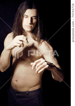 handsome young man with long hair naked torso on black background smiling, lifestyle people concept 74743716