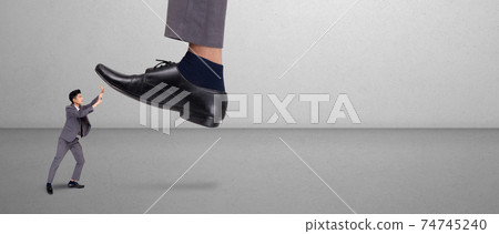 Foot of leader or boss with authority huge trample on frightened employee with bullying. Foot of leader or boss with authority huge trample on frightened employee with bullying. 74745240