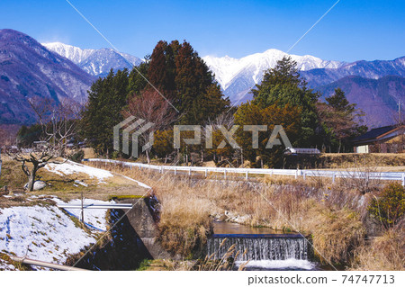 [Nagano Prefecture] Countryside scenery Clear stream and Komagatake flowing through the village 74747713