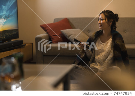 晚上看電視的年輕女子 74747934