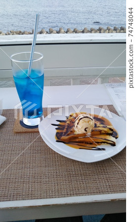 Photograph of pancakes and juice with the sea of Hokkaido in the background 74748044