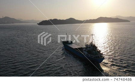 一艘貨船在竹原市馬托巴海灘的海岸上航行，以應對朝陽 74748486