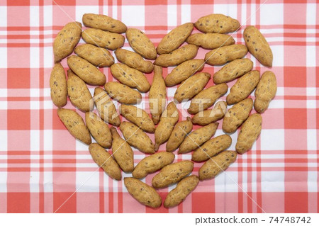 The cookies are spread out on the table in the shape of a heart 74748742