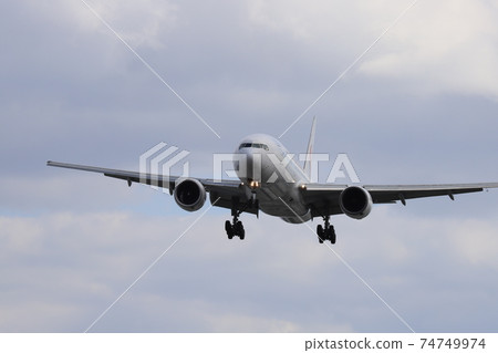 Landing scene of a passenger plane in the blue sky Landing scene of a passenger plane in the blue sky 74749974