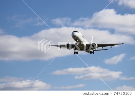 Landing of a passenger plane in the blue sky Landing of a passenger plane in the blue sky 74750163